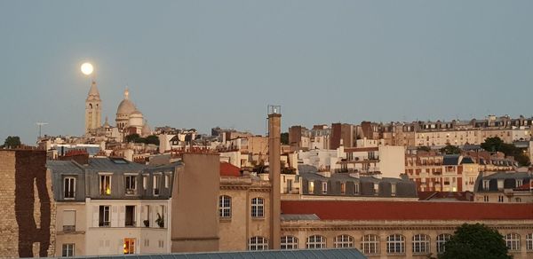 Buildings in city against clear sky