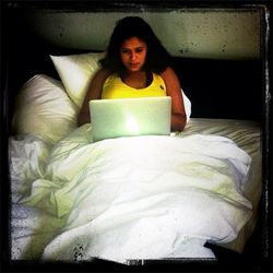 Portrait of young woman sitting on bed