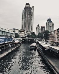 Boats in river with buildings in background