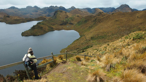 Tourist watching the parcacocha lagoon in the cayambe coca national park - ecuador