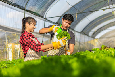 Botanists watering plants in greenhouse