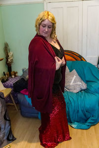 Woman looking away while standing on bed at home