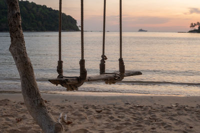 View of swing on beach during sunset