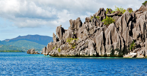 Scenic view of sea and mountains against sky