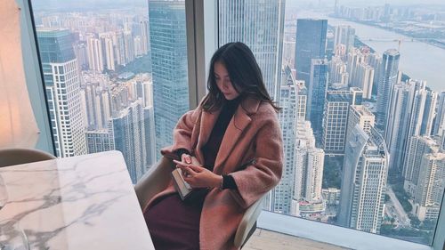 High angle view of woman using mobile phone at table