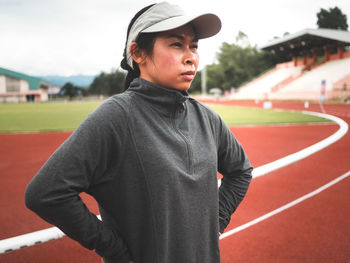 Woman looking away standing on running track