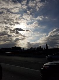 Cars on road against sky during sunset