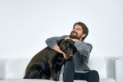 Man with dog sitting against wall