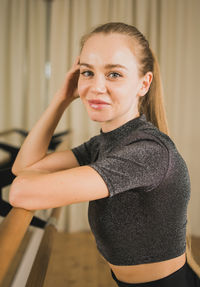 Portrait of young woman standing against wall