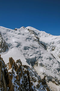 Scenic view of snowcapped mountains against clear blue sky