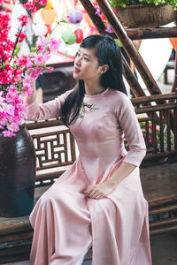 Girl looking flowers while sitting on bench