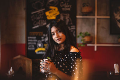 Portrait of a smiling young woman at restaurant