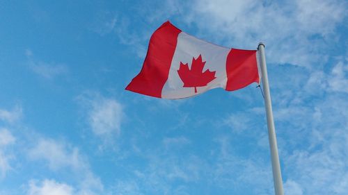 Low angle view of flag against blue sky