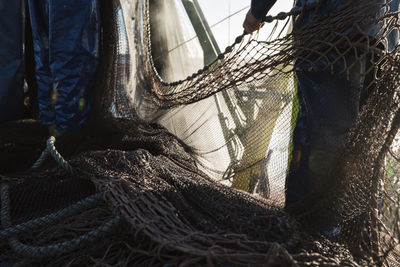 Low section of fishermen standing by fishing net