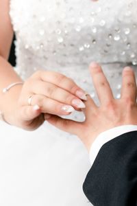 Midsection of bride putting ring on finger