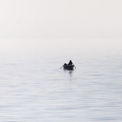 Swan swimming in sea against clear sky