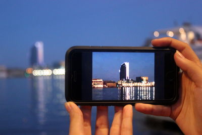 Cropped image of woman holding smart phone