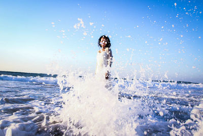 Man surfing on sea against clear sky