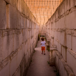 Rear view of a woman walking on wall