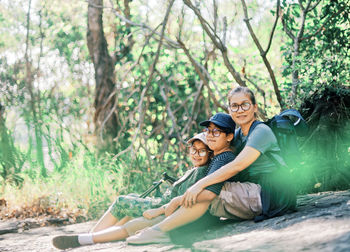 Portrait of mother and kids sitting at park