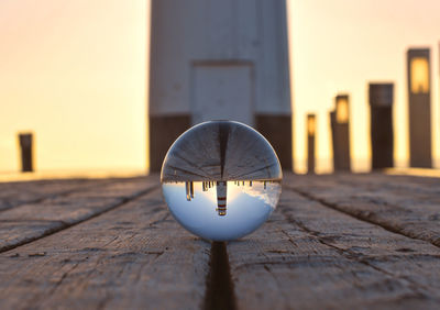 Close-up of umbrella on pier against sky during sunset