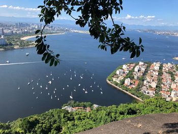 High angle view of townscape by sea against sky