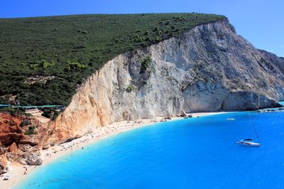 Scenic view of sea and mountains against clear blue sky