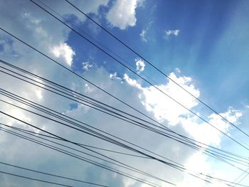 Low angle view of power cables against sky