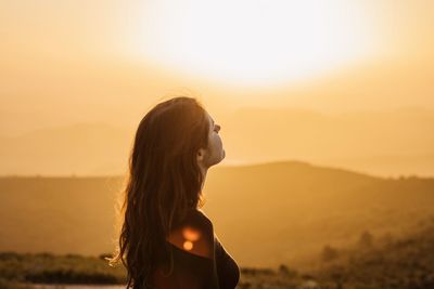 Portrait of woman standing against sky during sunset