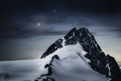 Scenic view of snow against sky at night