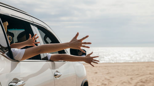 Side view of man with arms raised at beach