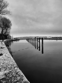 Pier on sea against cloudy sky