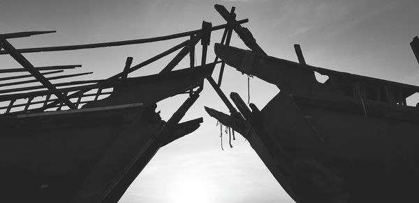 Low angle view of silhouette bridge against sky