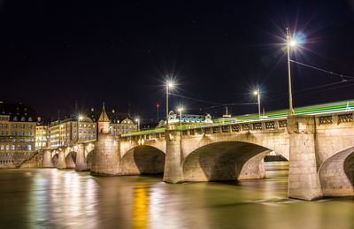 Bridge over river against sky at night