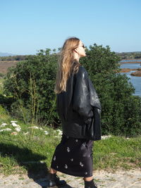 Side view of young woman standing on land