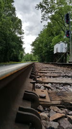 Railroad track against cloudy sky