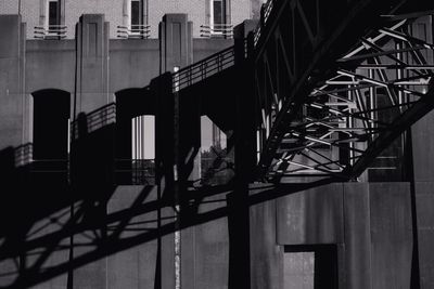 Silhouette bridge by buildings in city