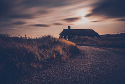 Built structure on land against sky during sunset