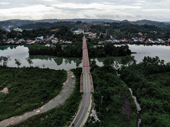 High angle view of road amidst trees and city against sky