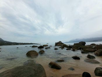 Rocks on beach against sky