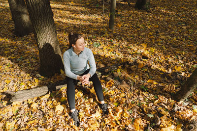 Beautiful girl listening to music and doing fitness or yoga in nature