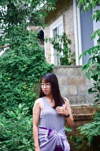 Full length of woman standing against plants