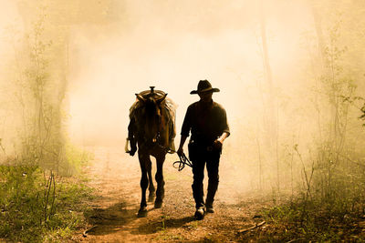 Rear view of people riding horse