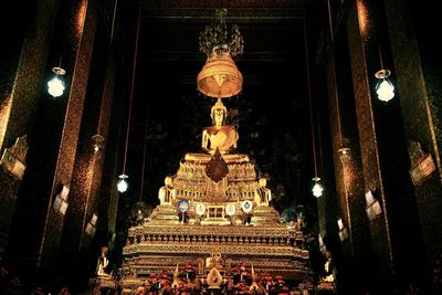 Low angle view of statue against illuminated building