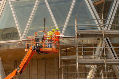 Workers on a platform in mobile safety while installing the electrical system at the library 