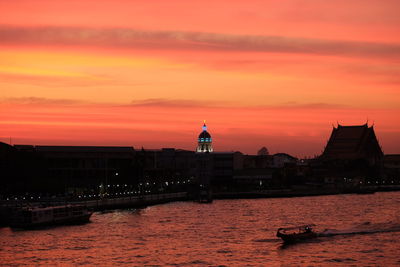 View of buildings at waterfront during sunset