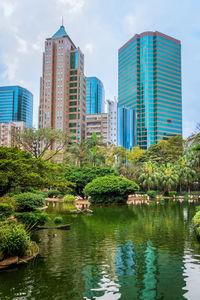 Lake and buildings against sky in city