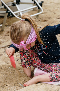 Rear view of girl playing with straw