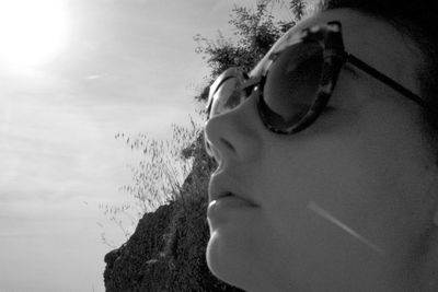 Close-up of girl wearing sunglasses against sky