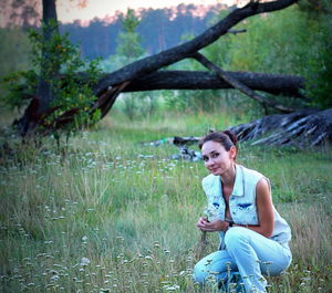 Full length of woman sitting on field